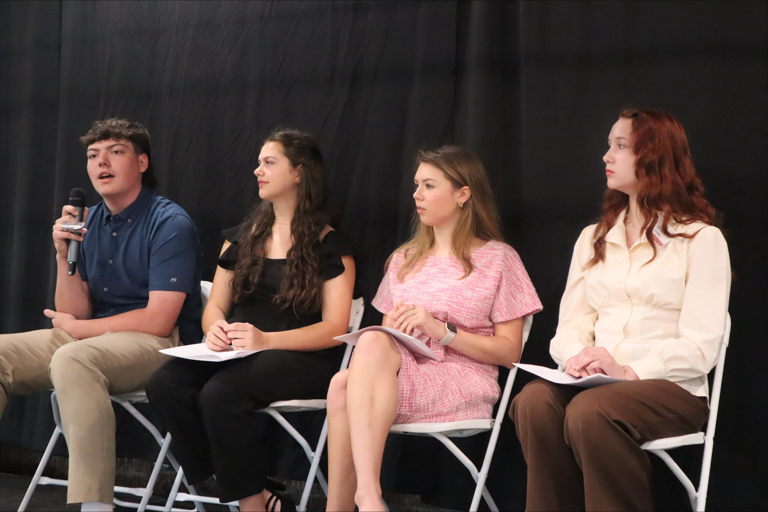 Four student panelists address the audience from on stage
