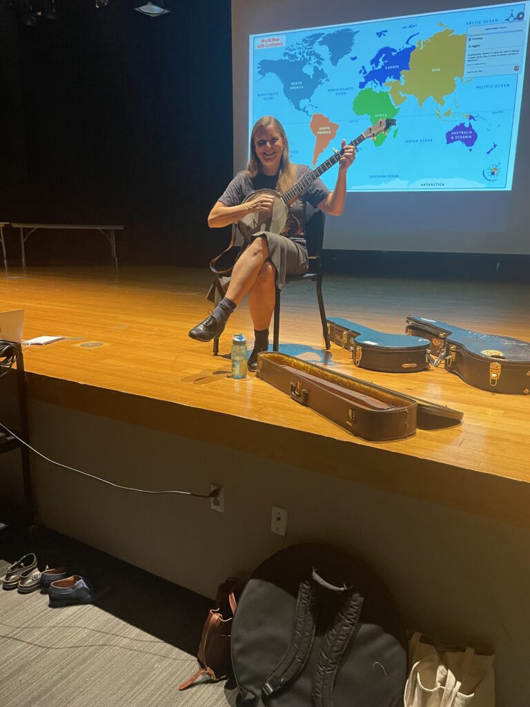 a woman smiling while playing a banjo